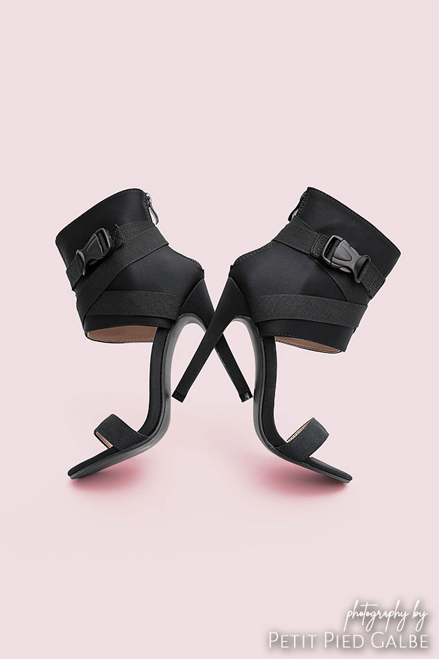 High heel sandals on pink background, placed in the way that they look similar to butterfly.