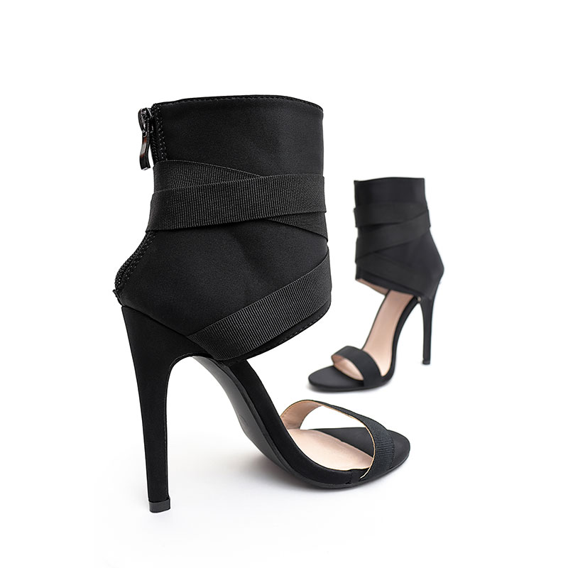 Black summer high heeled strappy sandals on white isolated background.