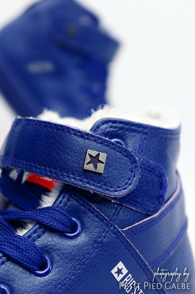 High top blue sneakers, close-up on laces and top of the shoe.