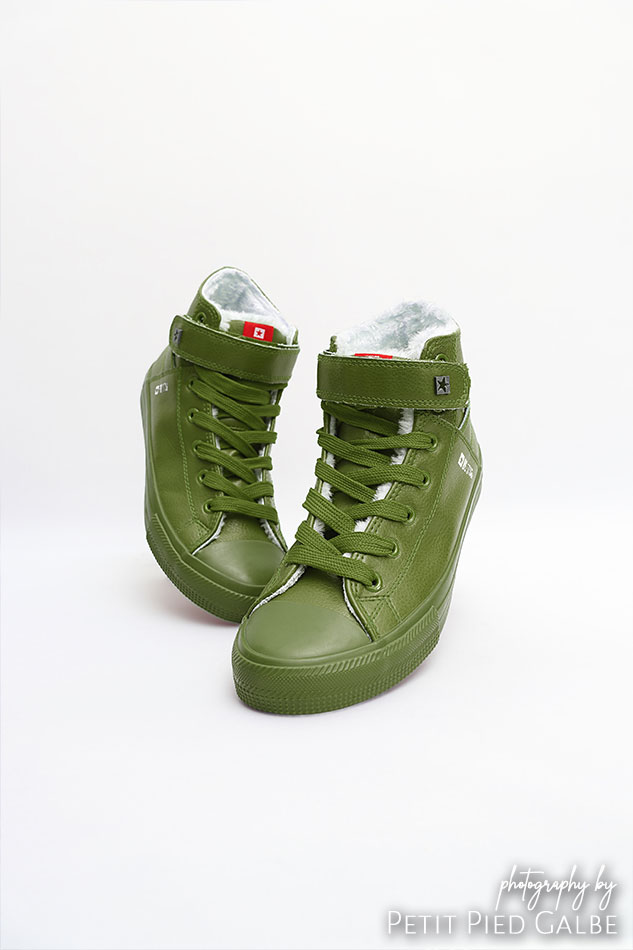 High top green sneakers on white background, still life capture.