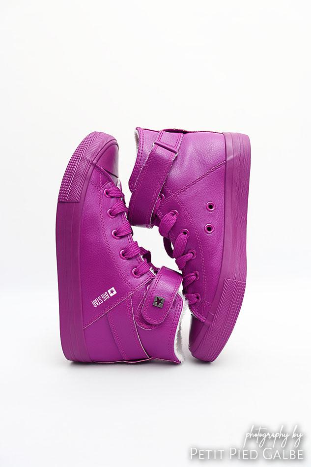 Purple sport shoes shown from sides on white background, still life shoot.