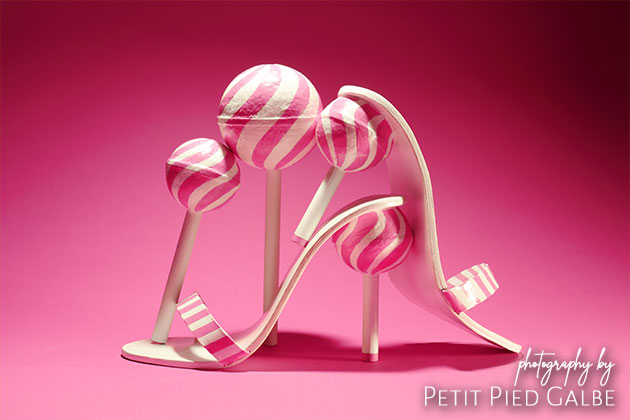 Handcrafted pink high heeled shoes and lollipops. One of a kind cute fashion concept by best shoe photographer.